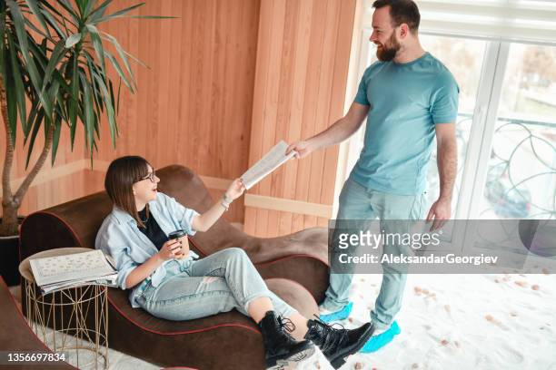 cute masseur is presenting the daily promotion to a client in salt room in spa center - protective footwear stock pictures, royalty-free photos & images