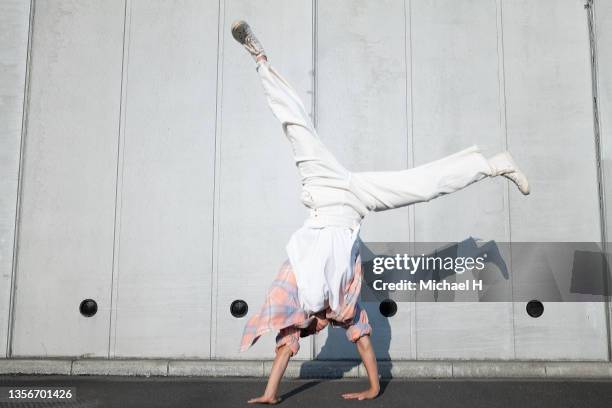 a skateboarder woman who cartwheels across the wall. - cartwheel stock pictures, royalty-free photos & images