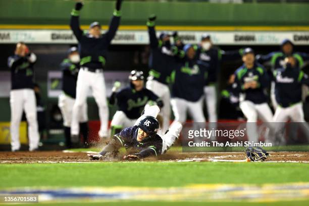 Yasutaka Shiomi of the Yakult Swallows slides safely into the home plate to score a run to make it 2-1 by the RBI single of Shingo Kawabata in the...