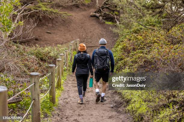 young couple hiking along coast - golden gate park stockfoto's en -beelden