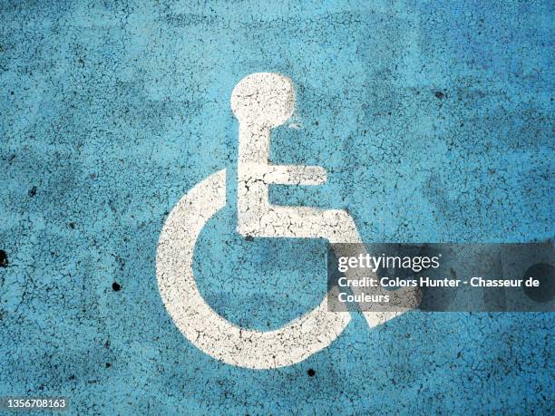 a wheelchair painted on a reserved parking space in paris - handicap foto e immagini stock