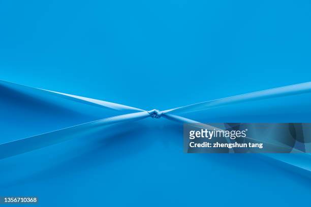 the blue ribbons are pulled together tightly - abstract partnership stock pictures, royalty-free photos & images