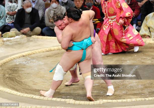 Tochinosin pushes Kotonowaka out of the ring to win on day fourteen of the Grand Sumo Kyushu Tournament at the Fukuoka Convention Center on November...