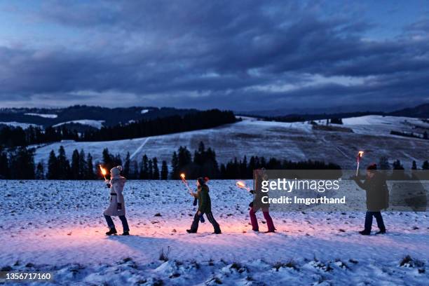 family walking in on hill with flaming torches - explorer imagens e fotografias de stock