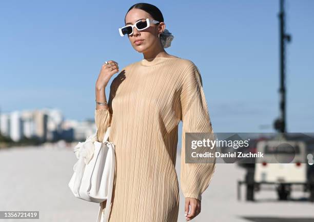 Dre Rojas is seen wearing a Issey Miyake Pleats Please dress and Telfar bag outside UNTITLED Art on December 01, 2021 in Miami, Florida.