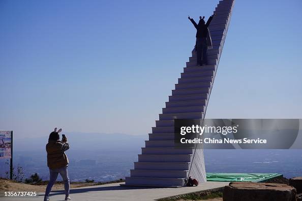 tourist poses for a photo on a sky stairway