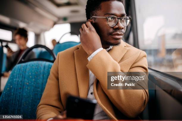 joven apuesto hombre de negocios en autobús público - man riding bus fotografías e imágenes de stock