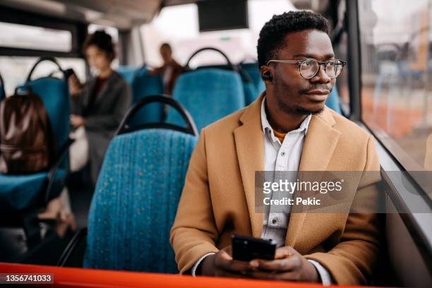 junger, gutaussehender geschäftsmann im öffentlichen bus - busfahrt stock-fotos und bilder