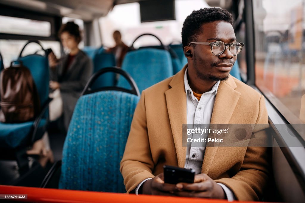 Giovane uomo d'affari bello in autobus pubblico