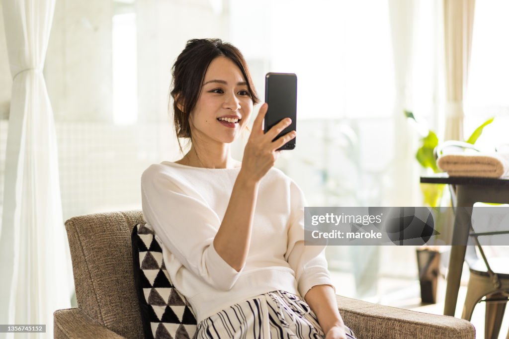 Young woman using a smartphone in her room