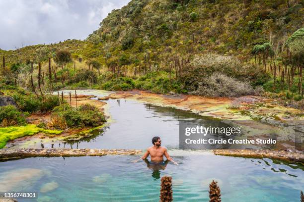 young man swimming in a hot springs  water - fonte termal imagens e fotografias de stock