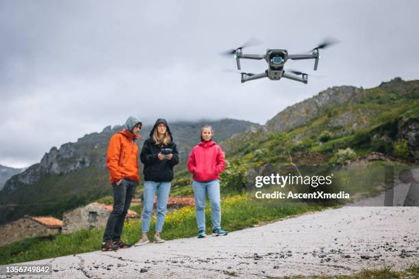 freunde fliegen drohne in bergen - flying drone stock-fotos und bilder