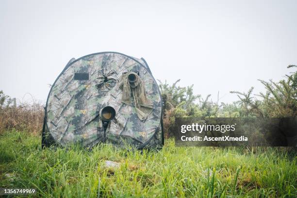 a hunter's blind with a camera on a lush meadow - hunting blind stock pictures, royalty-free photos & images