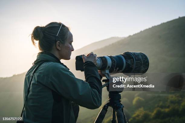 giovane donna osserva la scena lontana sulle montagne, dalla porta - attrezzatura fotografica foto e immagini stock