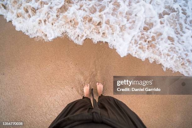 bare feet on the shore of the beach, cold and positive sensations, first person - womans bare feet stock-fotos und bilder