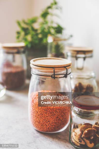 red lentils storage in glass jar on kitchen table - red lentil stock pictures, royalty-free photos & images