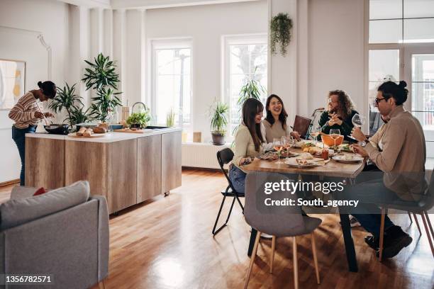 dinner party at home - group of people eating dinner stock pictures, royalty-free photos & images