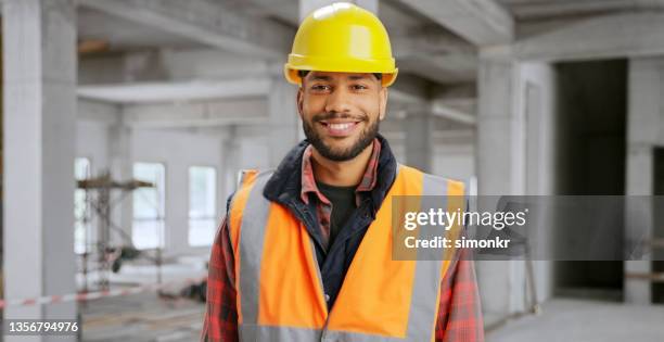 close-up of smiling male construction worker at site - builder stock pictures, royalty-free photos & images