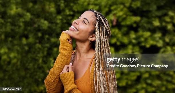 young woman with braided hair looking up outside and smiling - hand on chin stock pictures, royalty-free photos & images