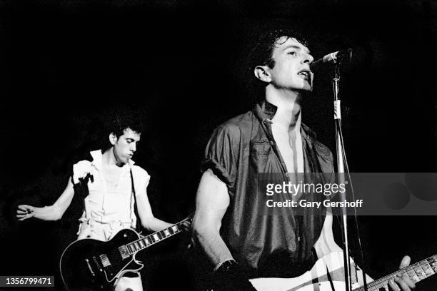 British Punk musicians Mick Jones and Joe Strummer , both of the group the Clash, play guitars as they perform onstage at the Capitol Theatre,...