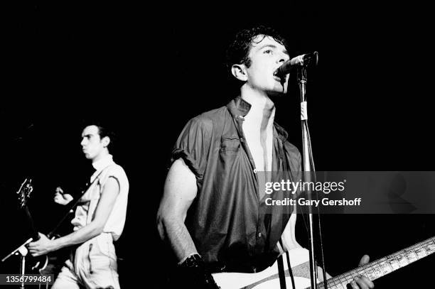 British Punk musicians Mick Jones and Joe Strummer , both of the group the Clash, play guitars as they perform onstage at the Capitol Theatre,...