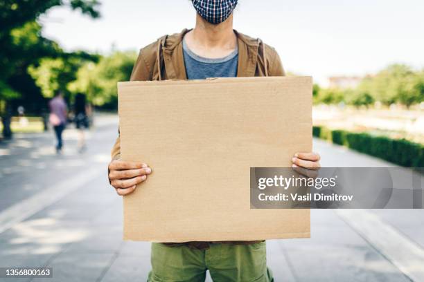 young man holding empty poster - plakkaat stockfoto's en -beelden