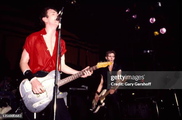 British Punk musicians Joe Strummer , on guitar, and Paul Simonon, on bass guitar, both of the group the Clash, perform onstage at the Capitol...