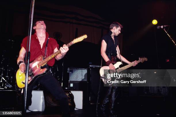 British Punk musicians Joe Strummer , on guitar, and Paul Simonon, on bass guitar, both of the group the Clash, perform onstage at the Capitol...