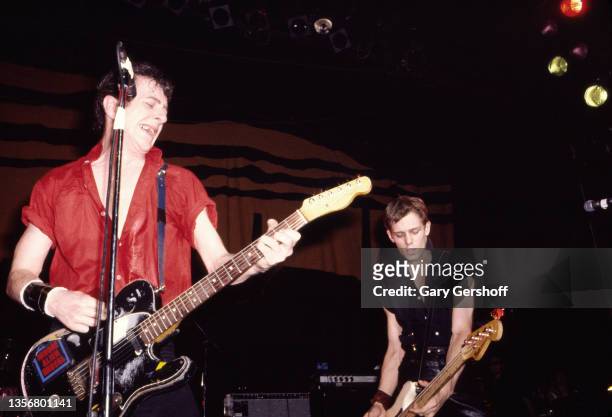 British Punk musicians Joe Strummer , on guitar, and Paul Simonon, on bass guitar, both of the group the Clash, perform onstage at the Capitol...