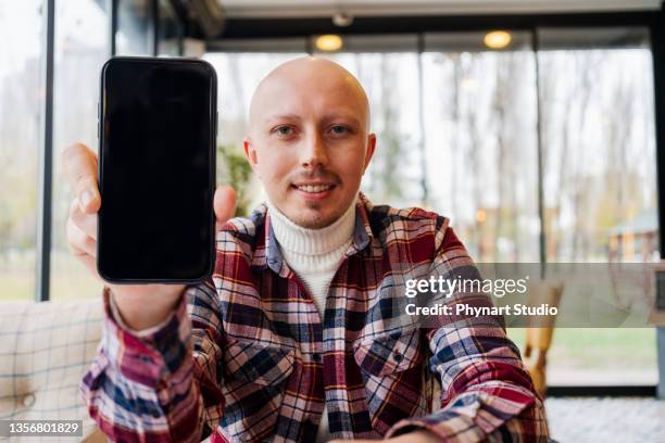 黒い携帯電話を持って見せる男 - guy with phone full image ストックフォトと画像