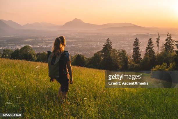 female hiker relaxes on grassy mountain ridge - austria stock pictures, royalty-free photos & images