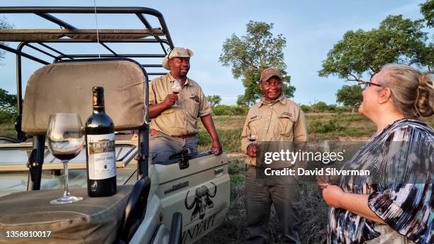 Visitors to the Inyati Game Lodge enjoy a Chateau Leoville Barton 2002 Bordeaux red wine with their local guide and tracker at sundown during a game...