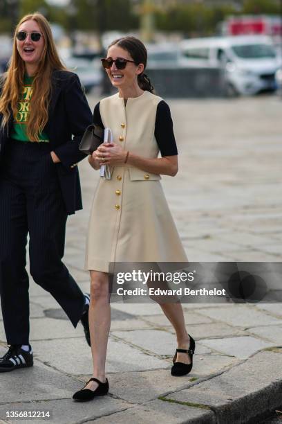 Guest wears sunglasses, a green with yellow inscriptions t-shirt, a black blazer jacket, black suit pants, white socks, black suede sneakers from...