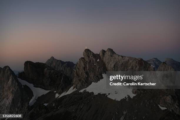 glowing summit cross on mountain range - karwendel stock-fotos und bilder