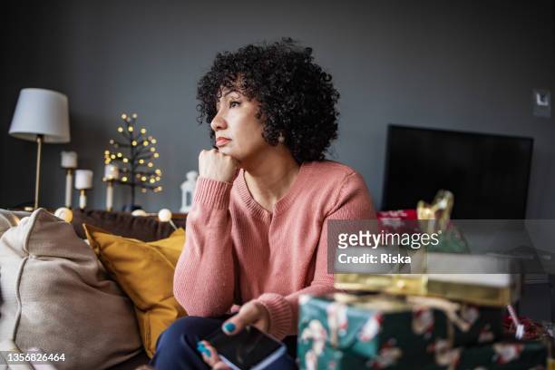 portrait of mature woman at home during christmas holidays - winter sadness stock pictures, royalty-free photos & images