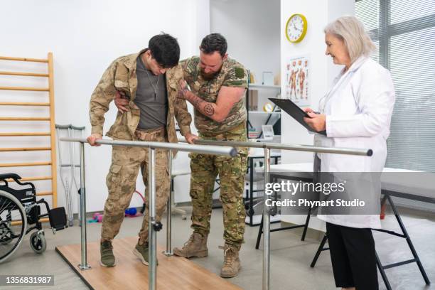 young military soldier uses parallel bars in a rehab center. - old trying to look young stock pictures, royalty-free photos & images