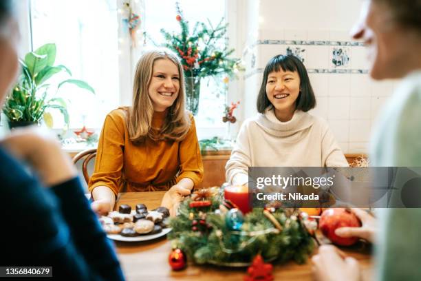 group of woman having christmas meal together at home - advent wreath stock pictures, royalty-free photos & images
