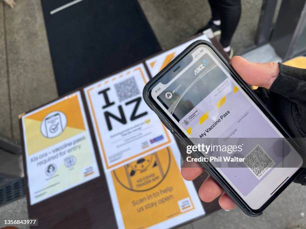 In this photo illustration a vaccine pass is displayed on a phone for entry into a cafe on December 03, 2021 in Auckland, New Zealand. New Zealand's...