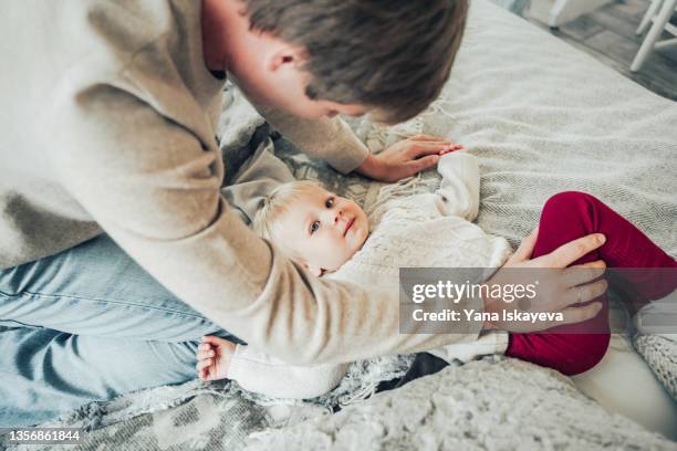 father putting his baby daughter in bed for a day nap, lying in bed - baby cotton wool stock pictures, royalty-free photos & images