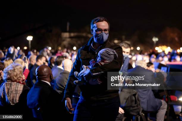 Chasten Buttigieg, husband of U.S. Secretary of Transportation Pete Buttigieg carries one of their children as they depart from the 2021 National...