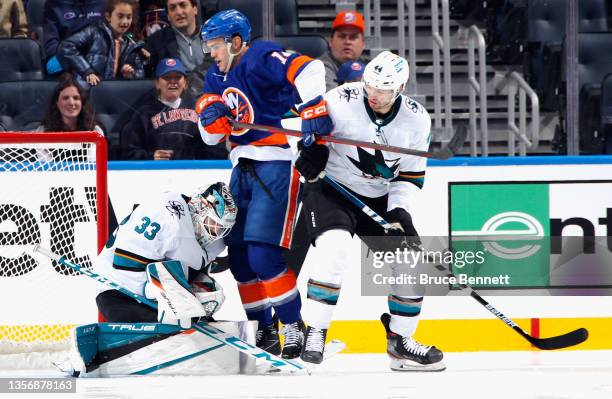 Adin Hill and Marc-Edouard Vlasic of the San Jose Sharks defend against Andy Andreoff of the New York Islanders during the third period at the UBS...