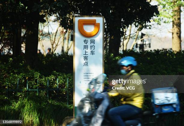 Food deliveryman rides past a designated pick-up point of Chinese ride-hailing platform Didi Chuxing on December 3, 2021 in Hangzhou, Zhejiang...