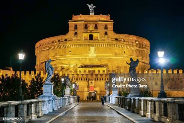 a suggestive night scene along ponte sant’angelo on the tiber river in the historic and baroque heart of rome - balustrade stock pictures, royalty-free photos & images