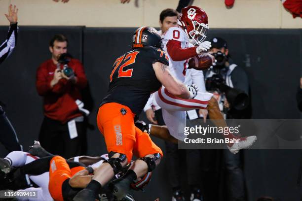 Cornerback Woodi Washington of the Oklahoma Sooners returns an interception 32 yards and tries to hurdle into the endzone as he is knocked out of...