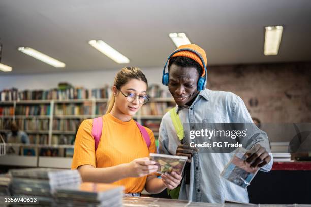 friends browsing in a music store - headphones in store stock pictures, royalty-free photos & images