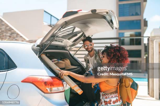 pareja de vacaciones abriendo el maletero del coche - brazil open fotografías e imágenes de stock