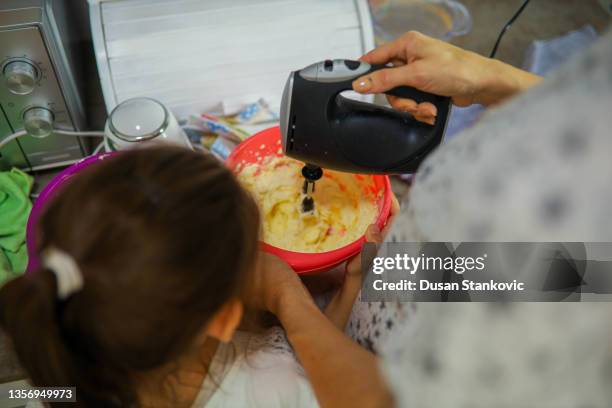 mother and daughter in the kitchen making filling for dessert - mixer stock pictures, royalty-free photos & images