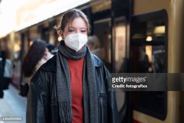 teenage girl wearing a mask, standing on a train station platform - commuter mask stock pictures, royalty-free photos & images