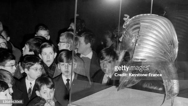 Enfants devant le masque funéraire du pharaon Toutankhamon lors de l'exposition 'Toutankhamon et son temps' au musée du Petit Palais à Paris, le 23...