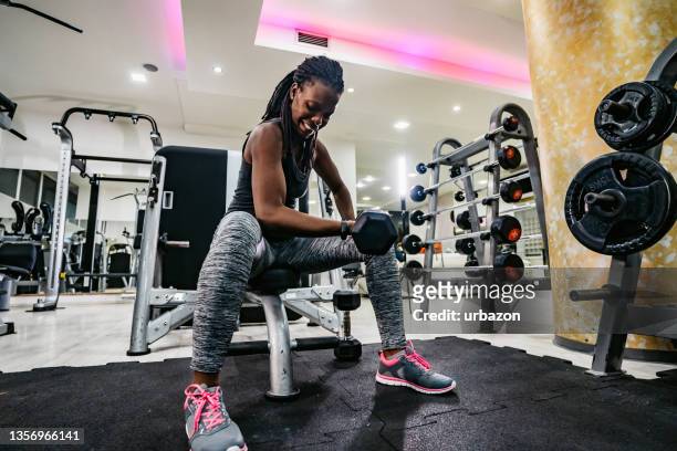 woman lifting weights at the gym - black female bodybuilder stock pictures, royalty-free photos & images